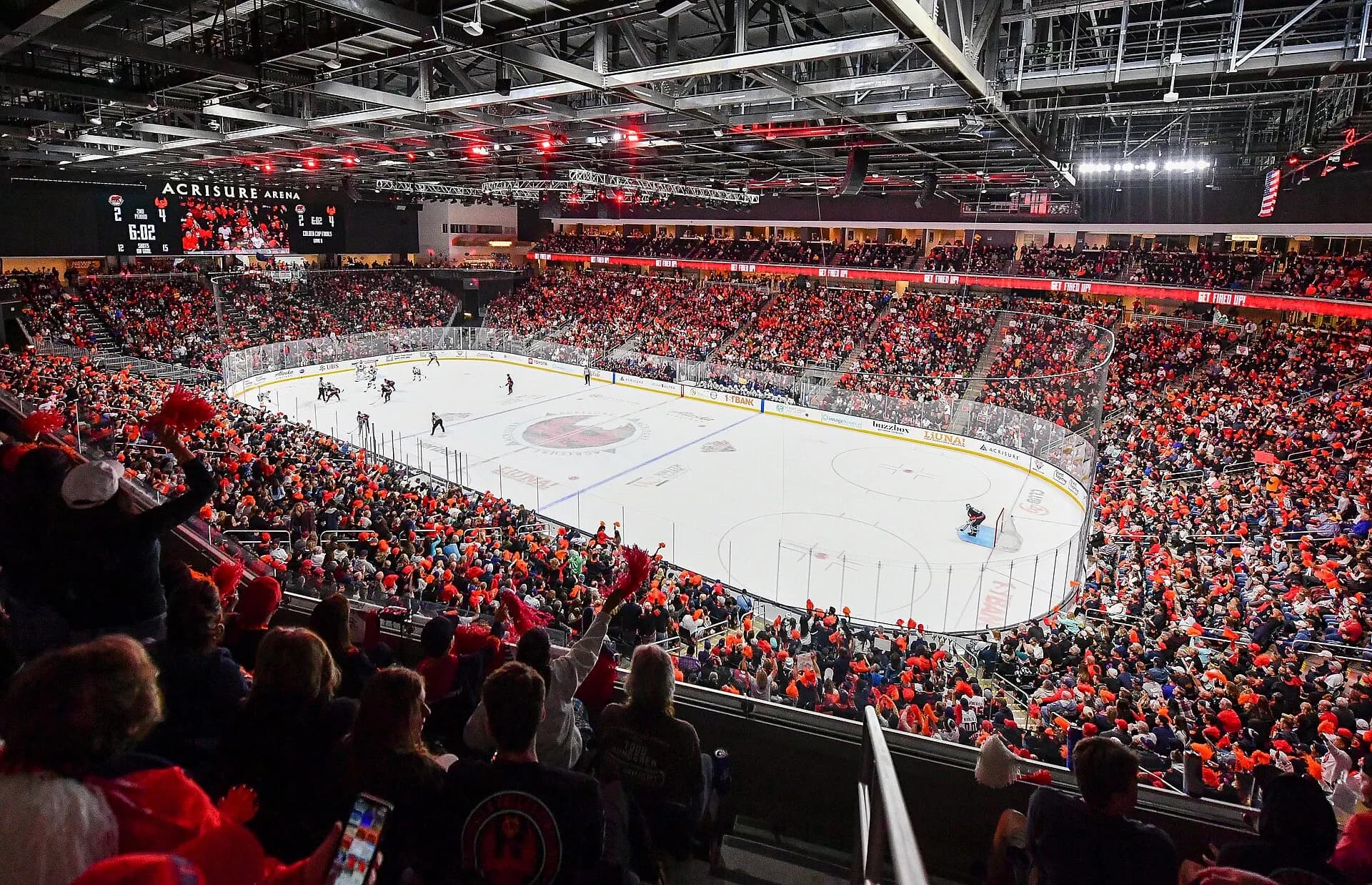A hockey game and crowd inside the seating bowl at Acrisure Arena.