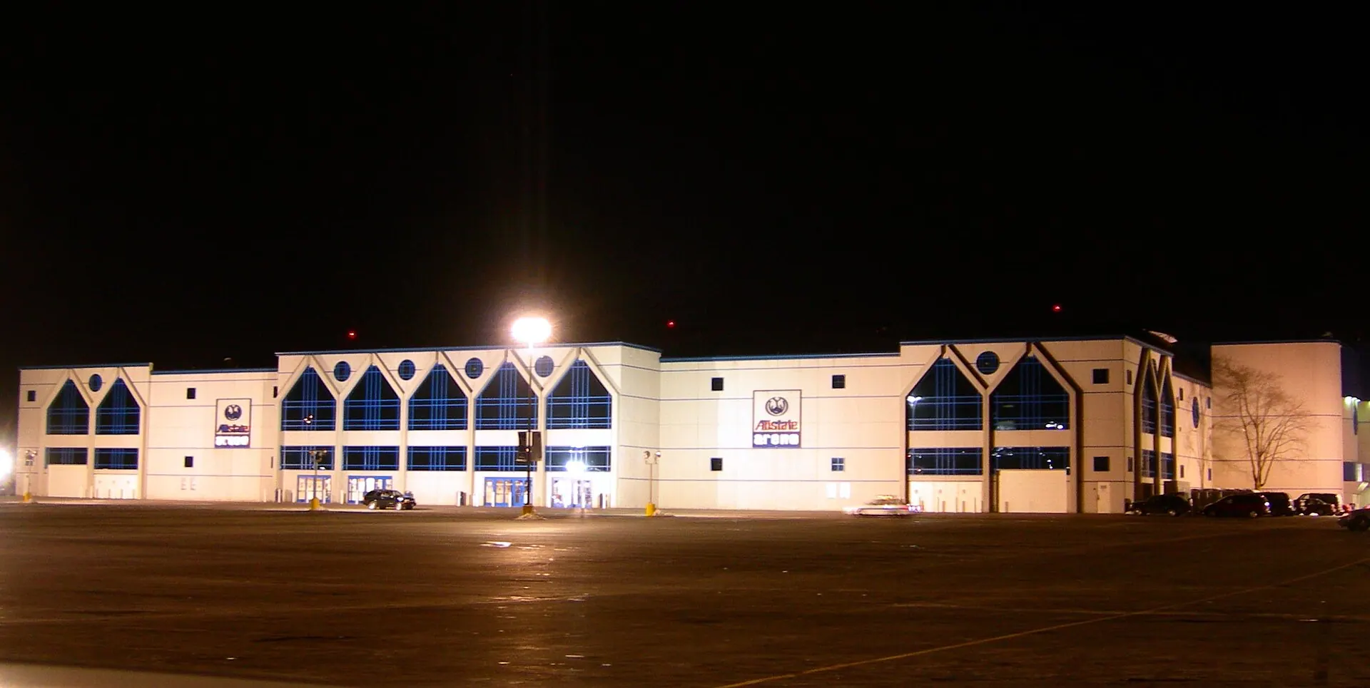 Wide nighttime exterior view of Allstate Arena and its main entrance.