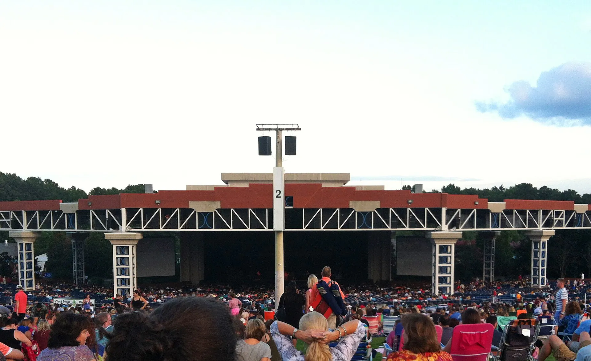 Wide audience-level view across the lawn and covered stage at Coastal Credit Union Music Park at Walnut Creek.