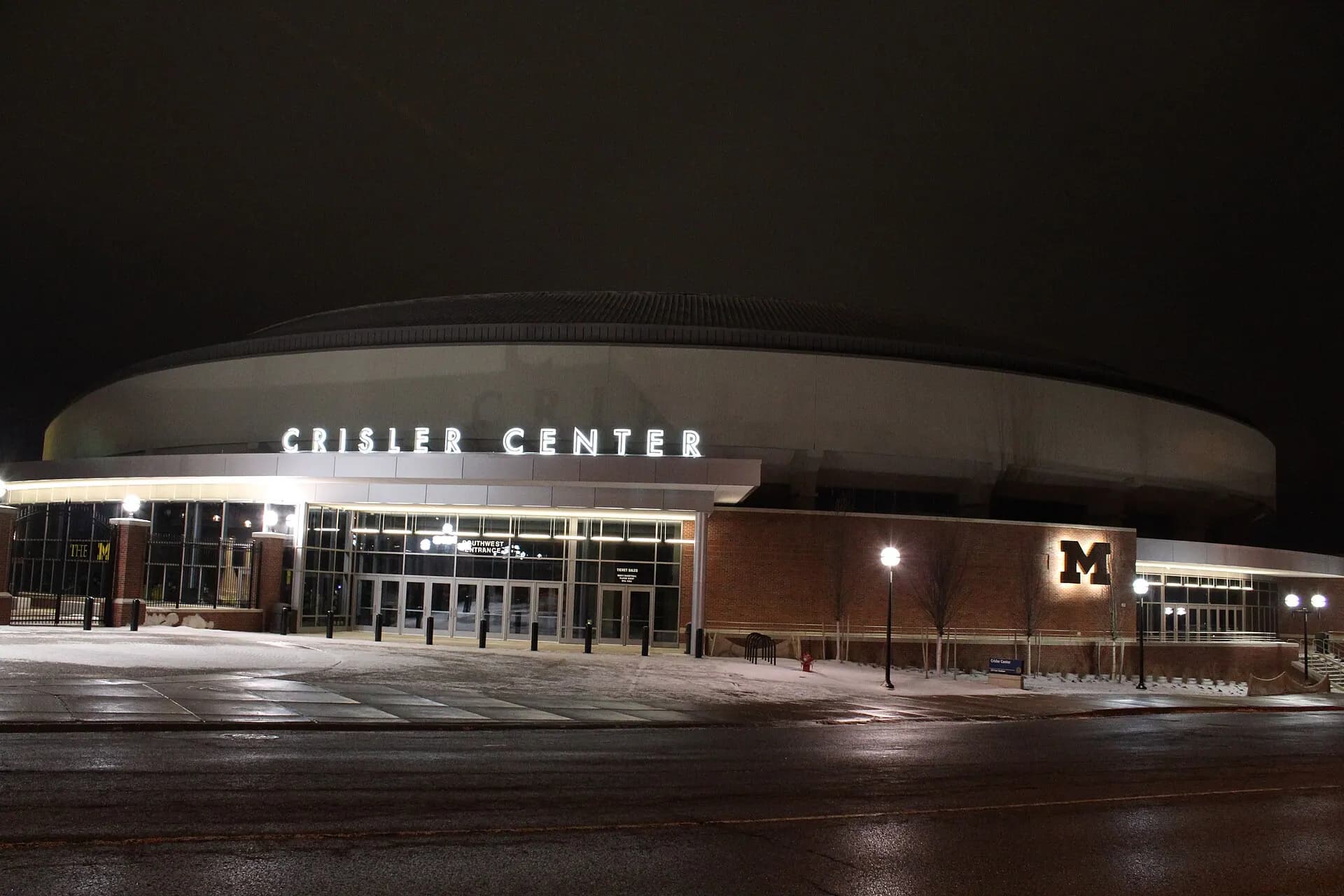 Crisler Center's illuminated exterior on a snowy night at the University of Michigan.