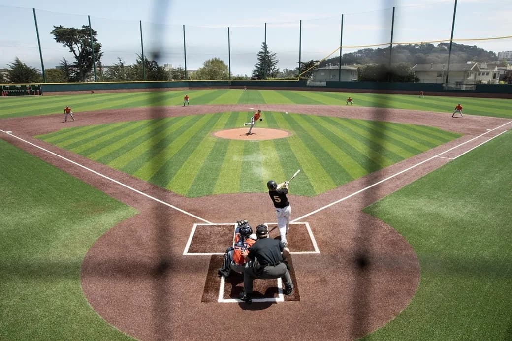 Benedetti Diamond’s complete synthetic diamond from behind home plate during a Pepperdine game in the official collection labeled for 2017. Jamie Soja is credited in the source. The historical image retains foreground netting and identifies no individual spectator camera seat.