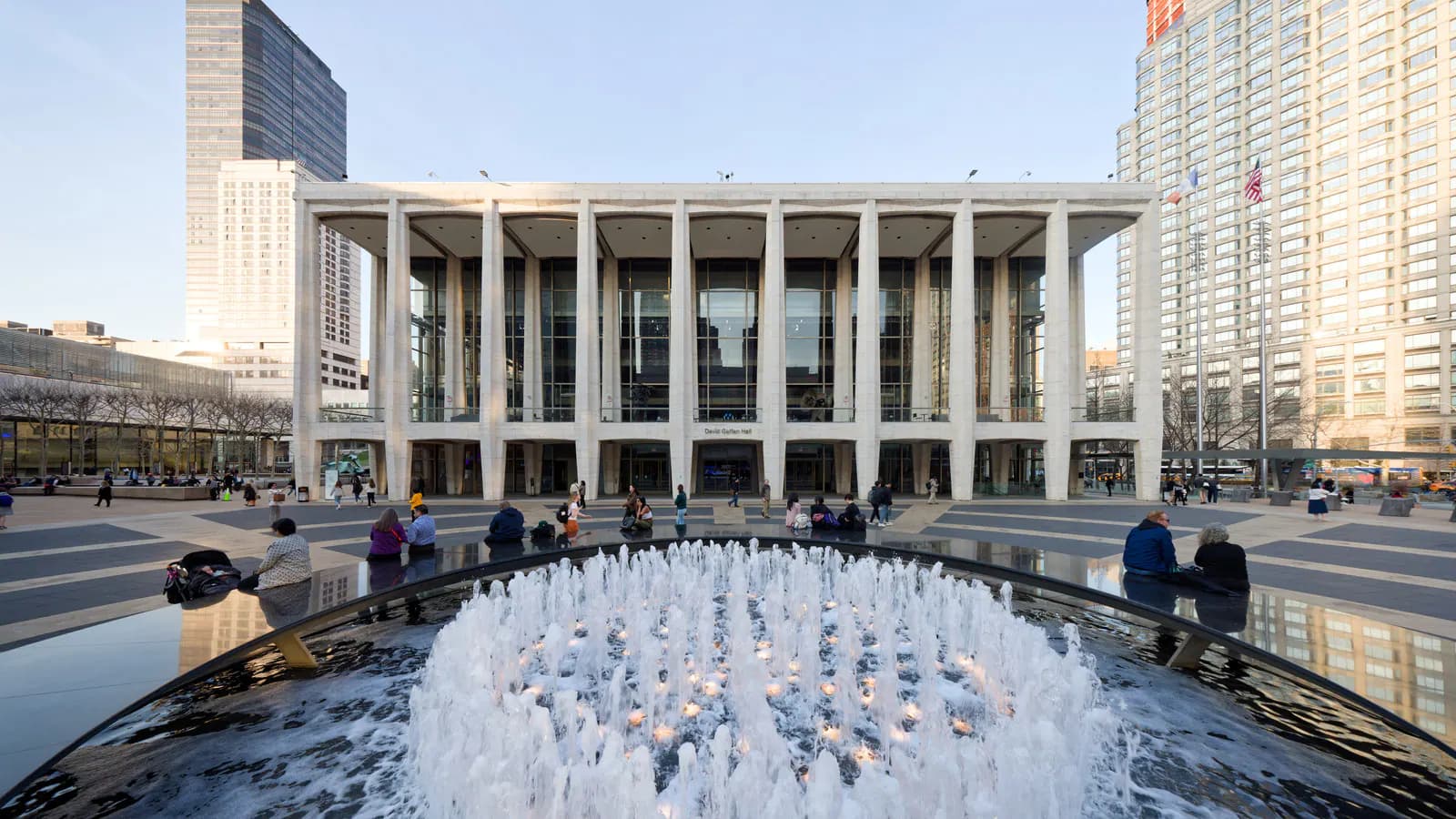 David Geffen Hall's full Lincoln Center facade behind the plaza fountain.