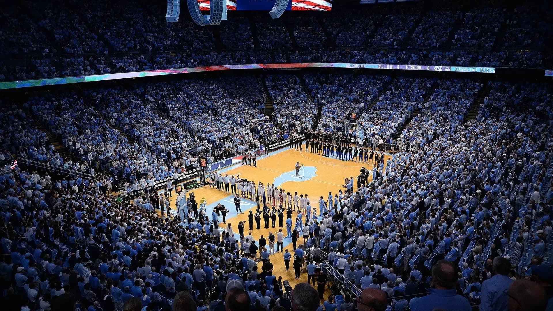 A wide occupied-bowl view of the Dean E. Smith Center, with the court and both seating levels visible, published on Carolina Athletics’ current facility page. The photograph is undated; the upload path does not establish its capture date, and the crowd, court presentation and event configuration can differ for your visit.