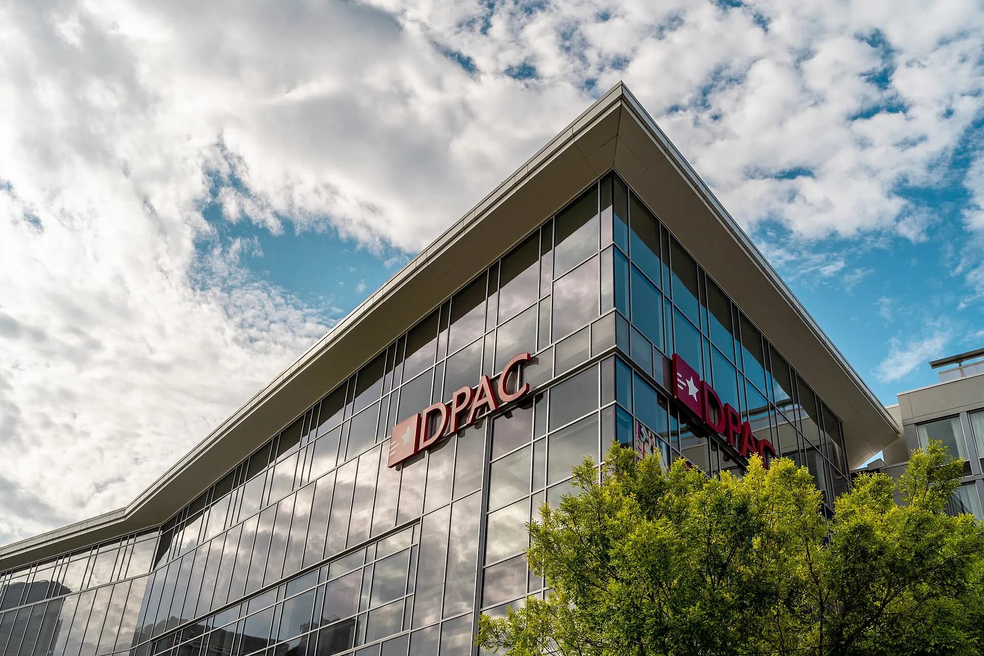 The modern exterior and entrance of the Durham Performing Arts Center.