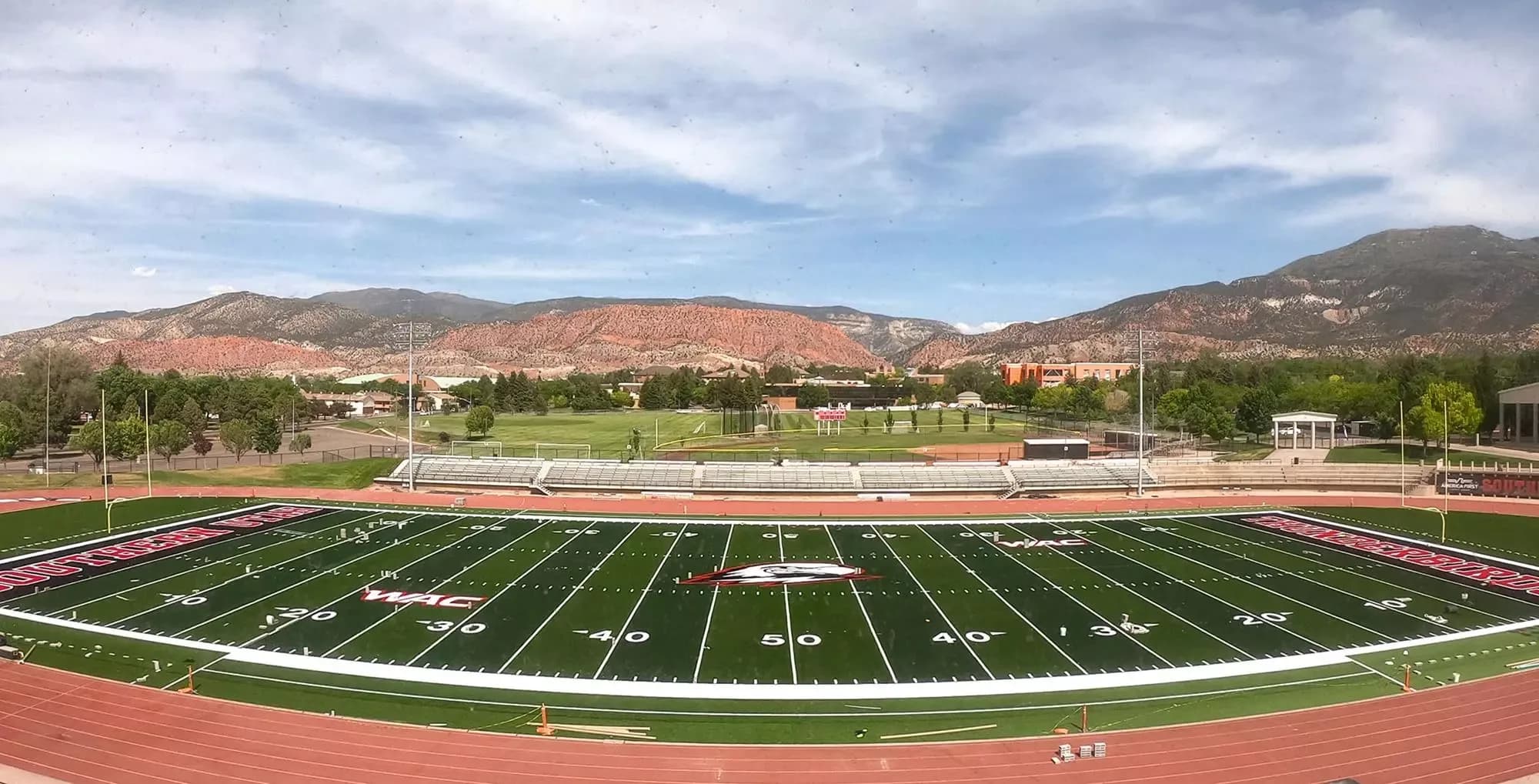 Eccles Coliseum’s football field and east-side seating with Cedar City’s mountain backdrop, in an older official facility photo.