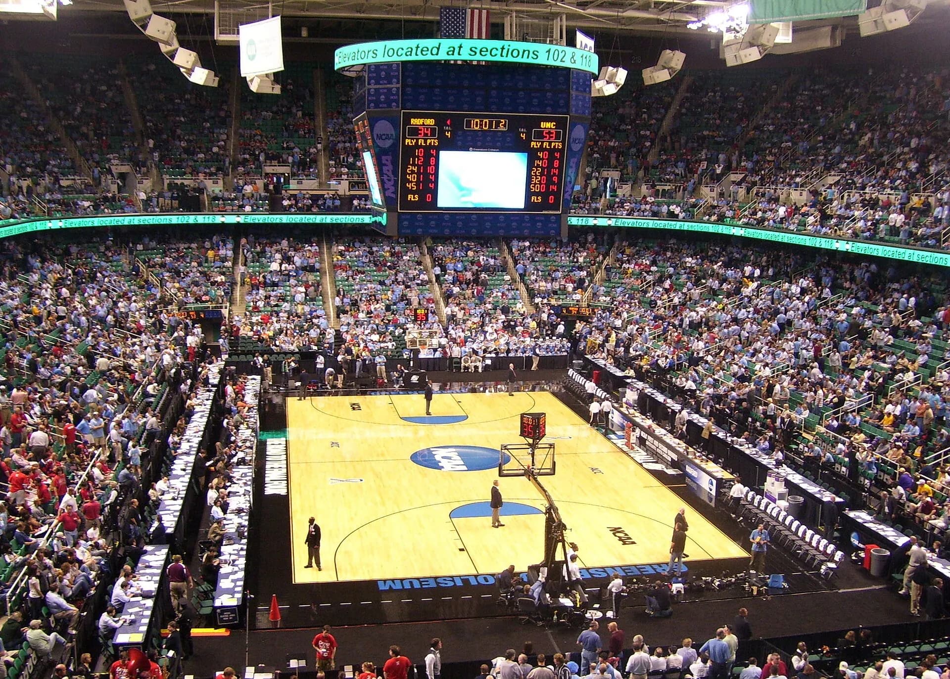A packed basketball crowd surrounds the court inside First Horizon Coliseum.