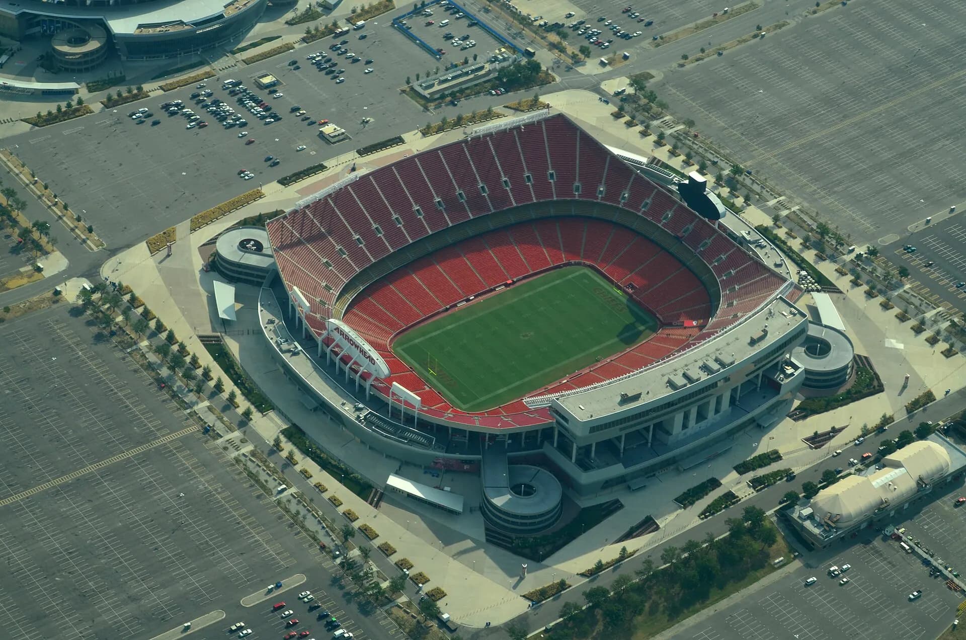 Wide aerial view of Arrowhead Stadium's full seating bowl and surrounding parking lots.