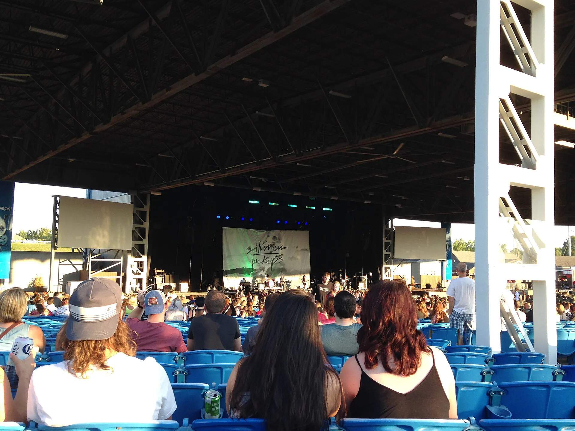 Wide view across the lawn toward the covered stage at Hollywood Casino Amphitheatre near St. Louis.