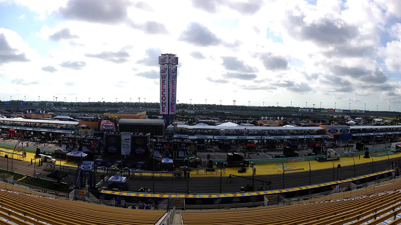 Panoramic view across Homestead-Miami Speedway's frontstretch, infield, grandstands, and scoring tower.