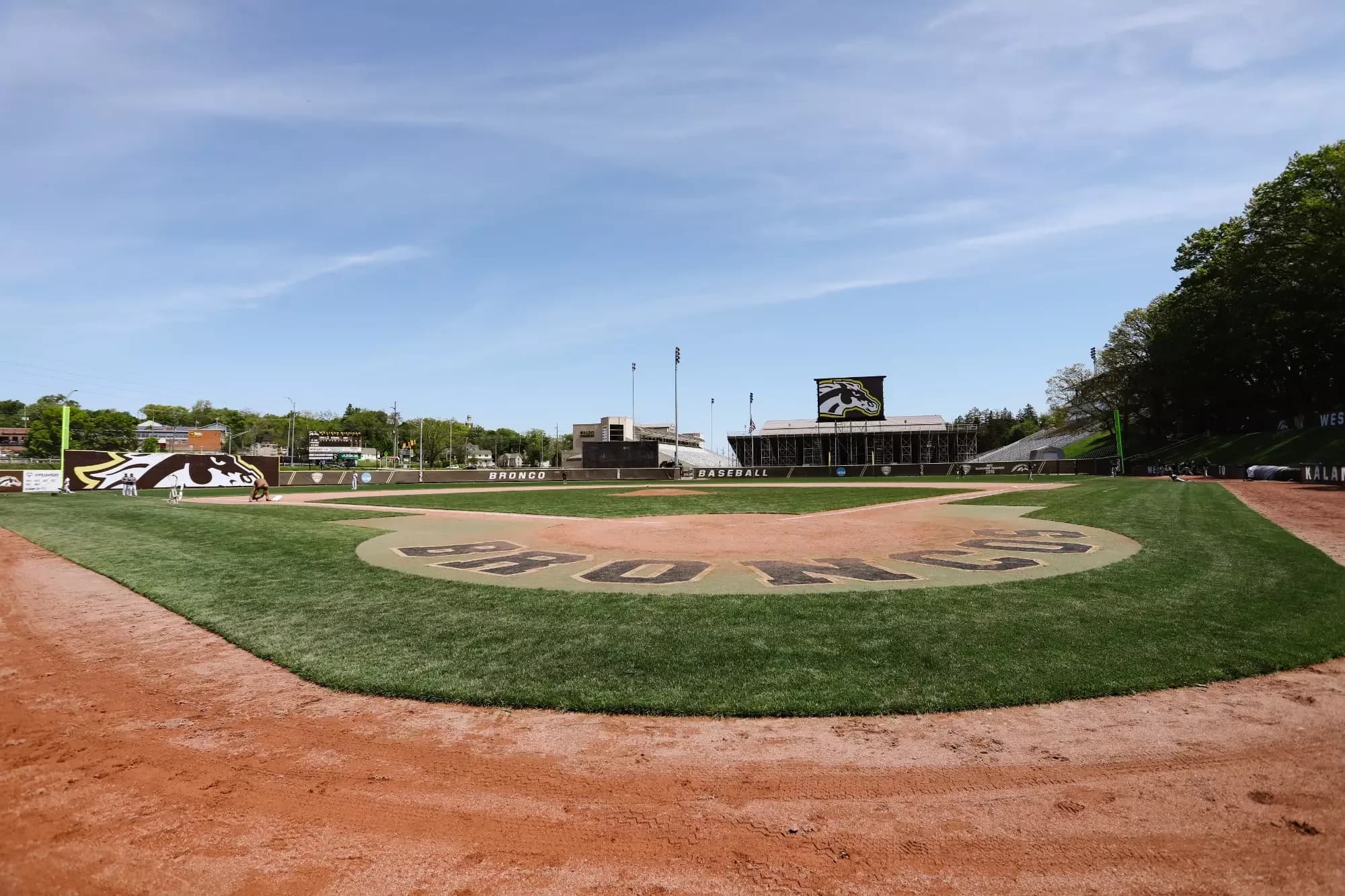 Robert J. Bobb Stadium at Hyames Field’s diamond, gold grandstand and surrounding campus in Western Michigan Athletics’ official collection. This wide field view supplies orientation; no exact capture date or numbered spectator camera seat is provided.