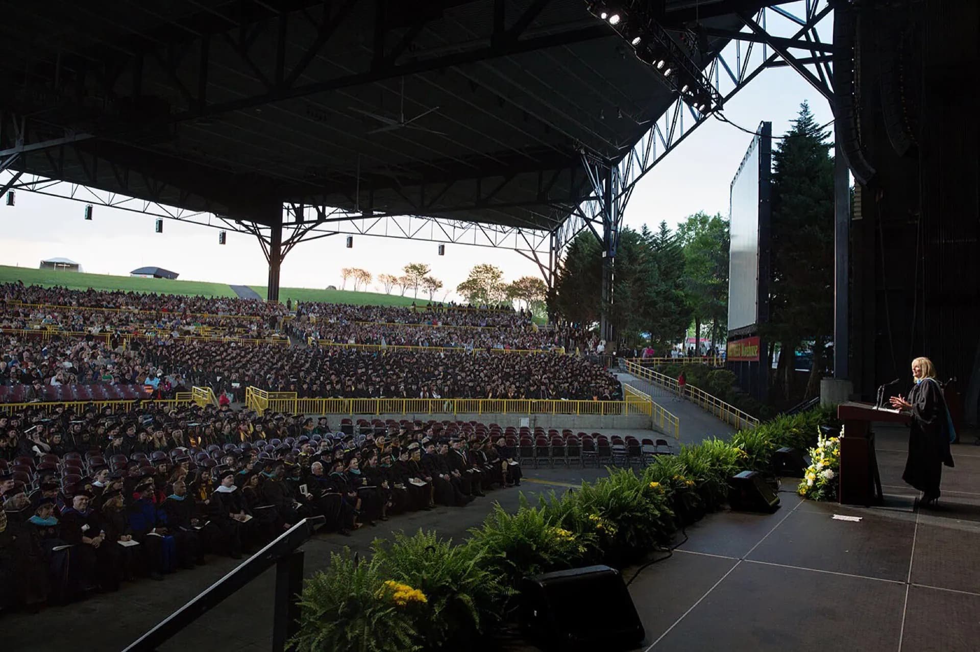 A daytime crowd facing the stage inside Jiffy Lube Live.
