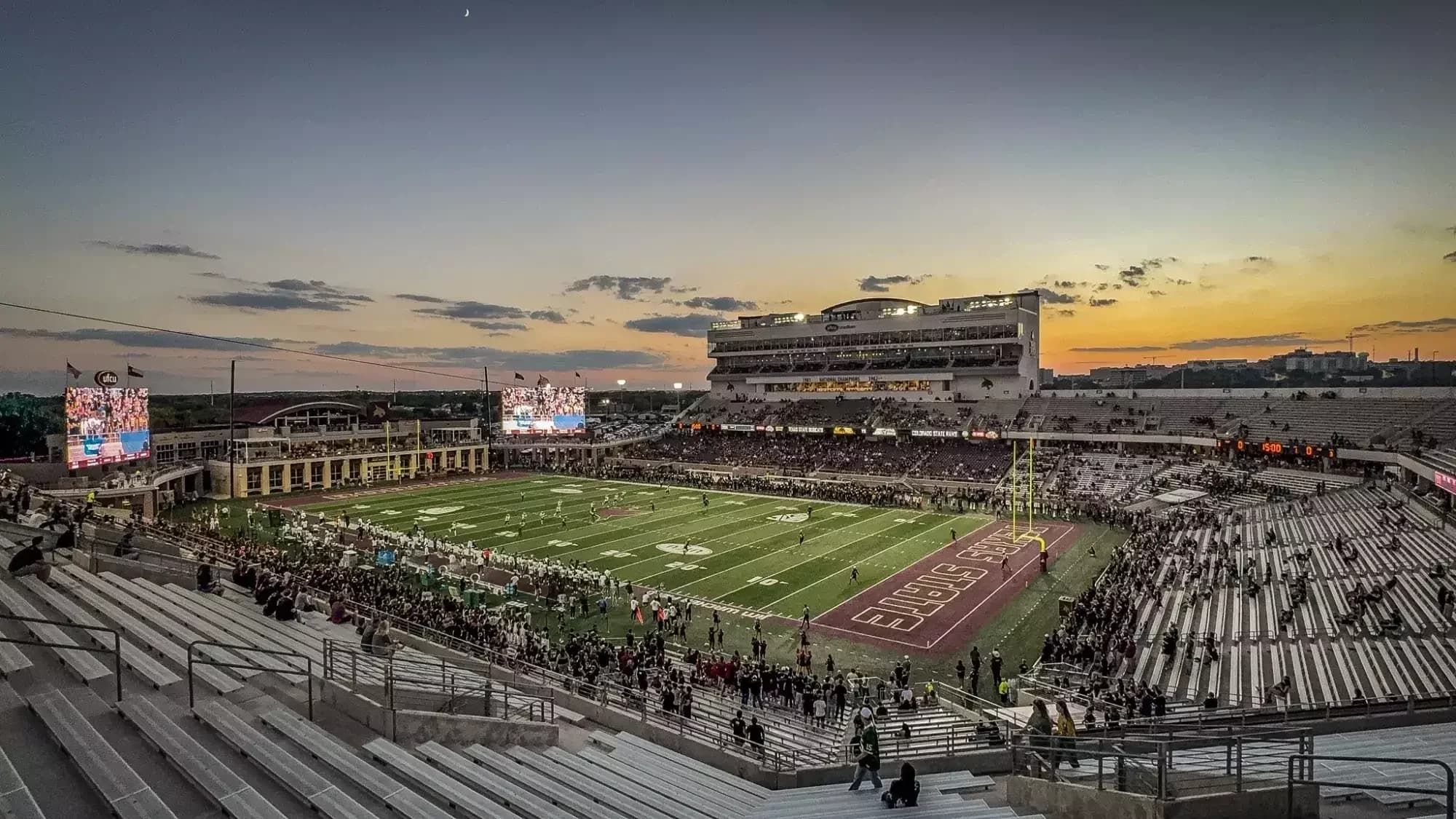 Wide view across UFCU Stadium’s field, lower bowl, end-zone seating and west grandstand at dusk. Published in Texas State’s current facility gallery; capture date unstated. Use the reviewed 2026 section and gate charts for current access.