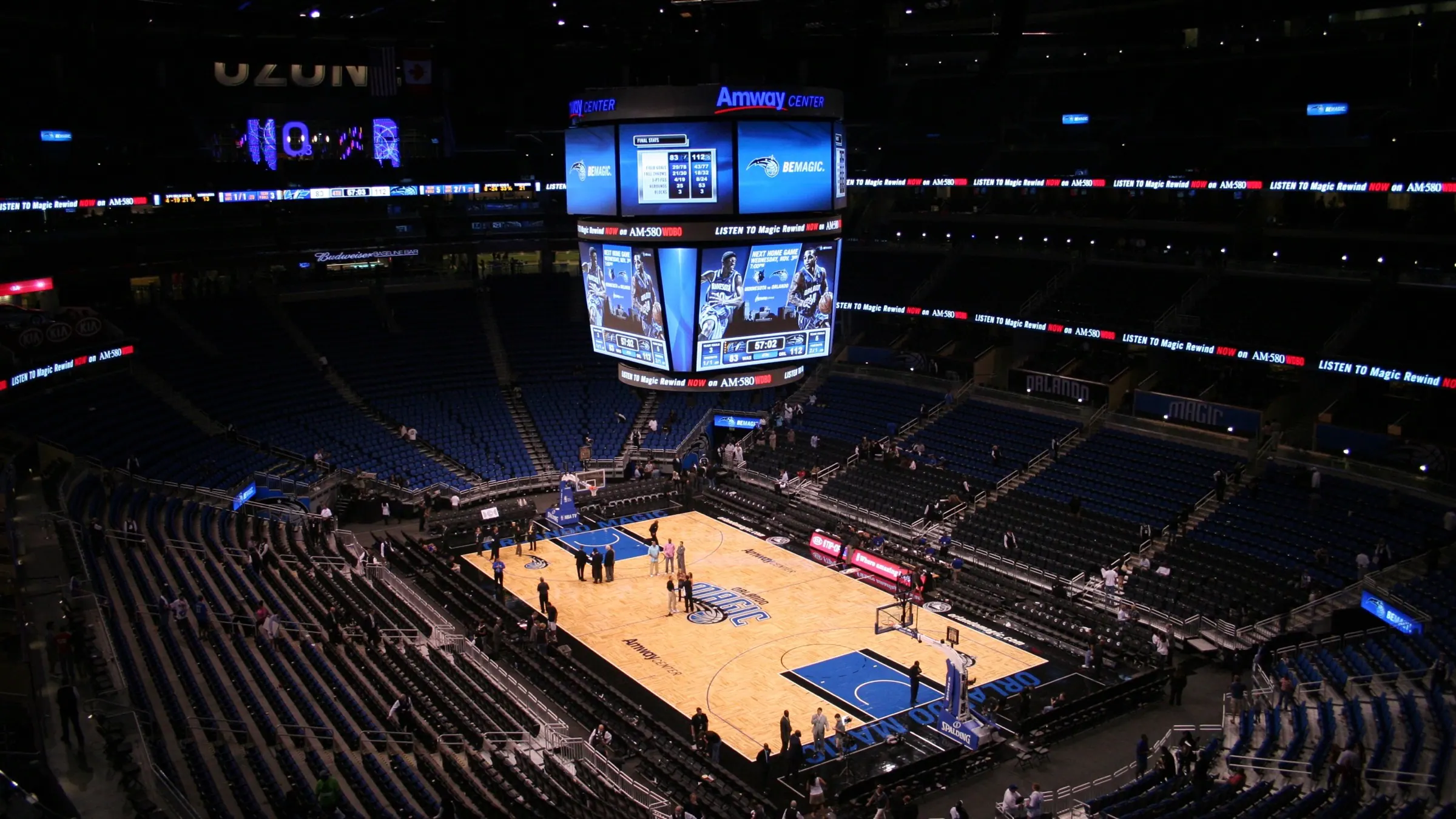 Wide view of the basketball court, scoreboard, and seating bowl inside Kia Center.