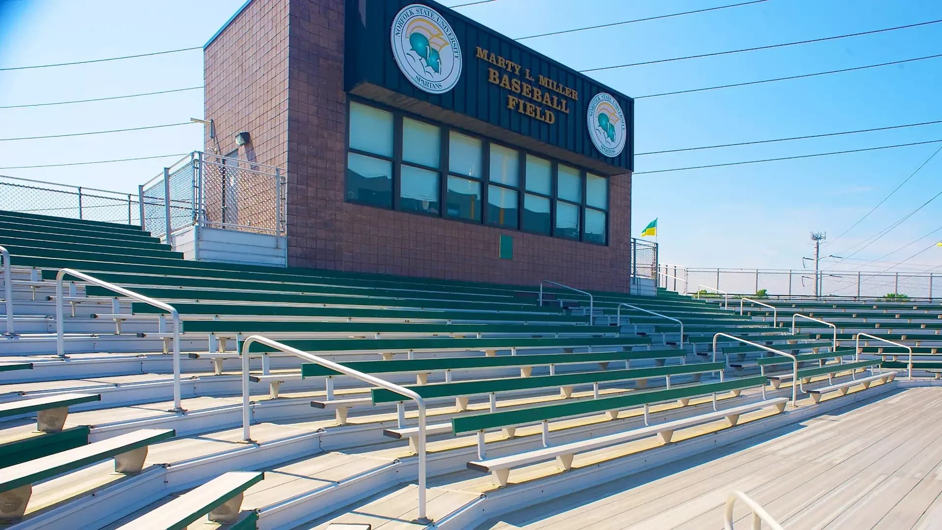 Marty L. Miller Field’s green metal bleachers and signed press box in Norfolk State’s official collection. The photograph retains steps, rails and fencing and does not establish a step-free route or public press-box access; no exact capture date is supplied.