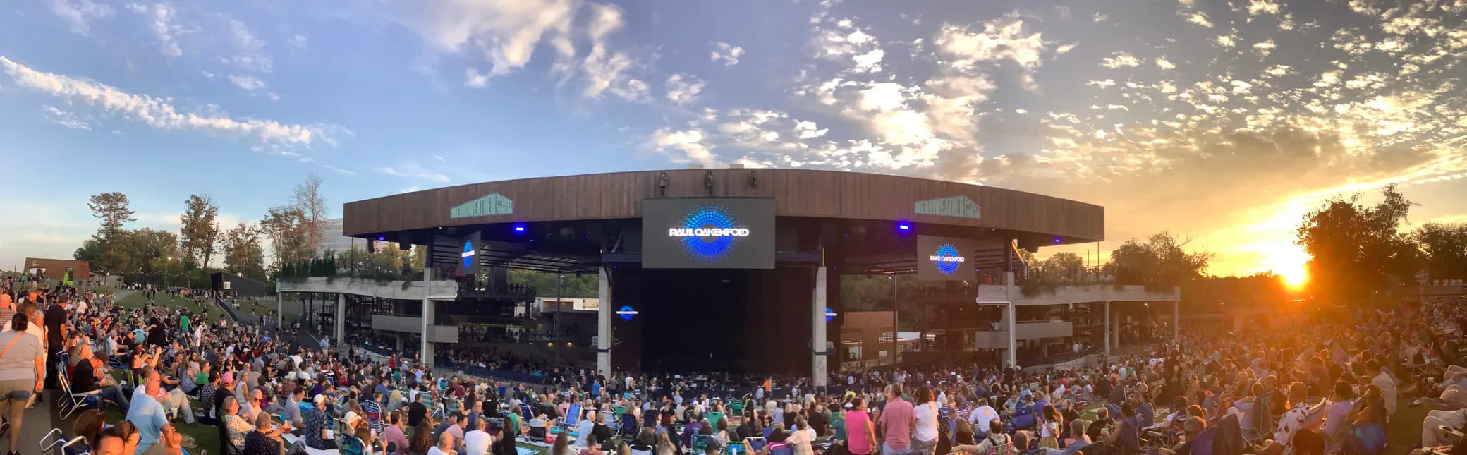 Super-wide sunset crowd view from the lawn toward the stage at Merriweather Post Pavilion.