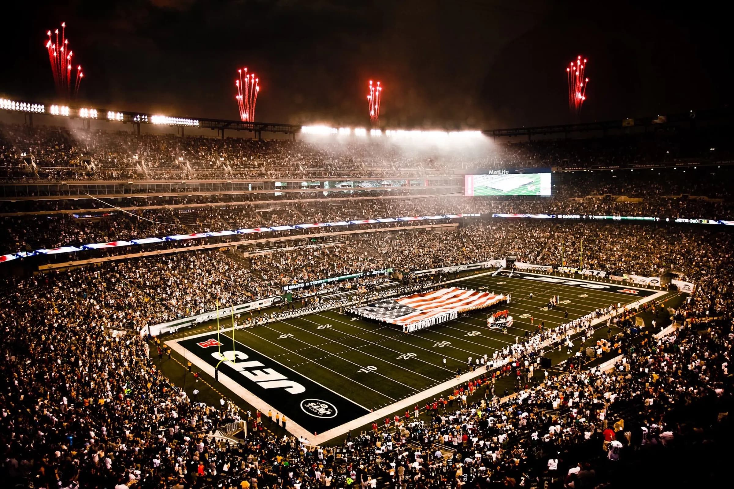 MetLife Stadium — Service members unfurl flag at NY Jets first home game at new Meadowlands Stadium.