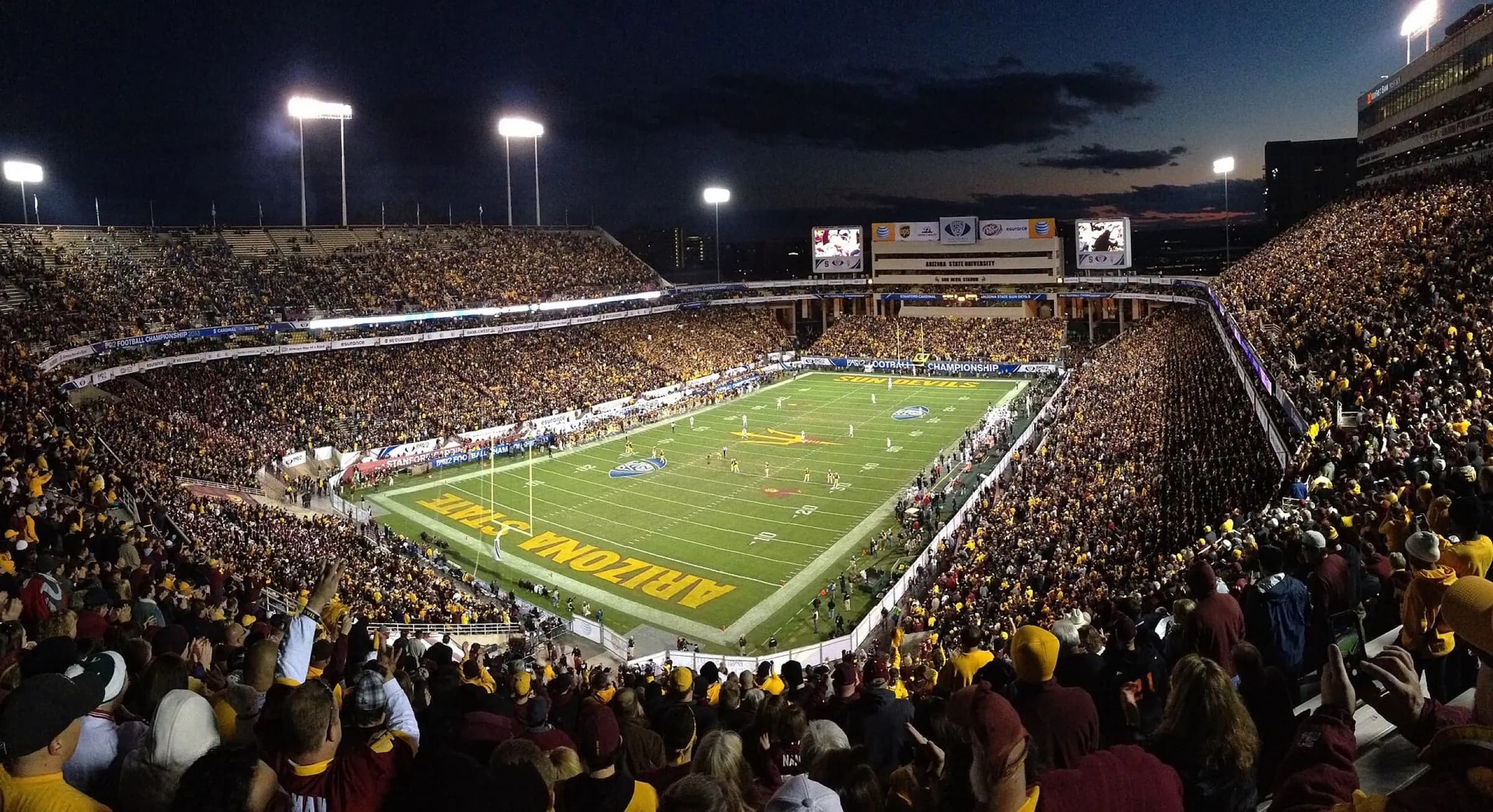 Wide game-day view across Mountain America Stadium's field, stands, and mountain backdrop.