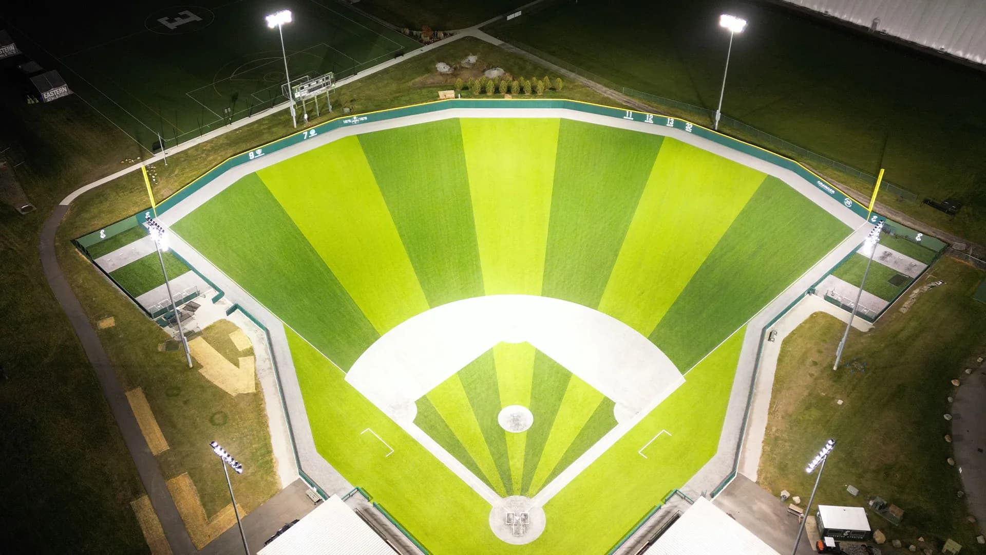 Oestrike Stadium’s actual full-field synthetic turf and gray infield under the lights in Eastern Michigan Athletics’ recent facility collection. The official description identifies these as completed 2025 upgrades. This is an aerial orientation view, without an exact capture date or numbered spectator camera seat.