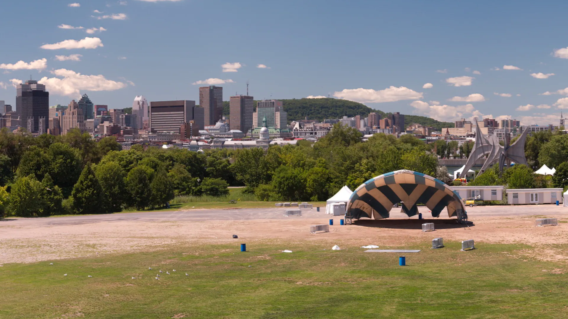 Wide view of an outdoor concert stage and event lawn at Parc Jean-Drapeau in Montreal