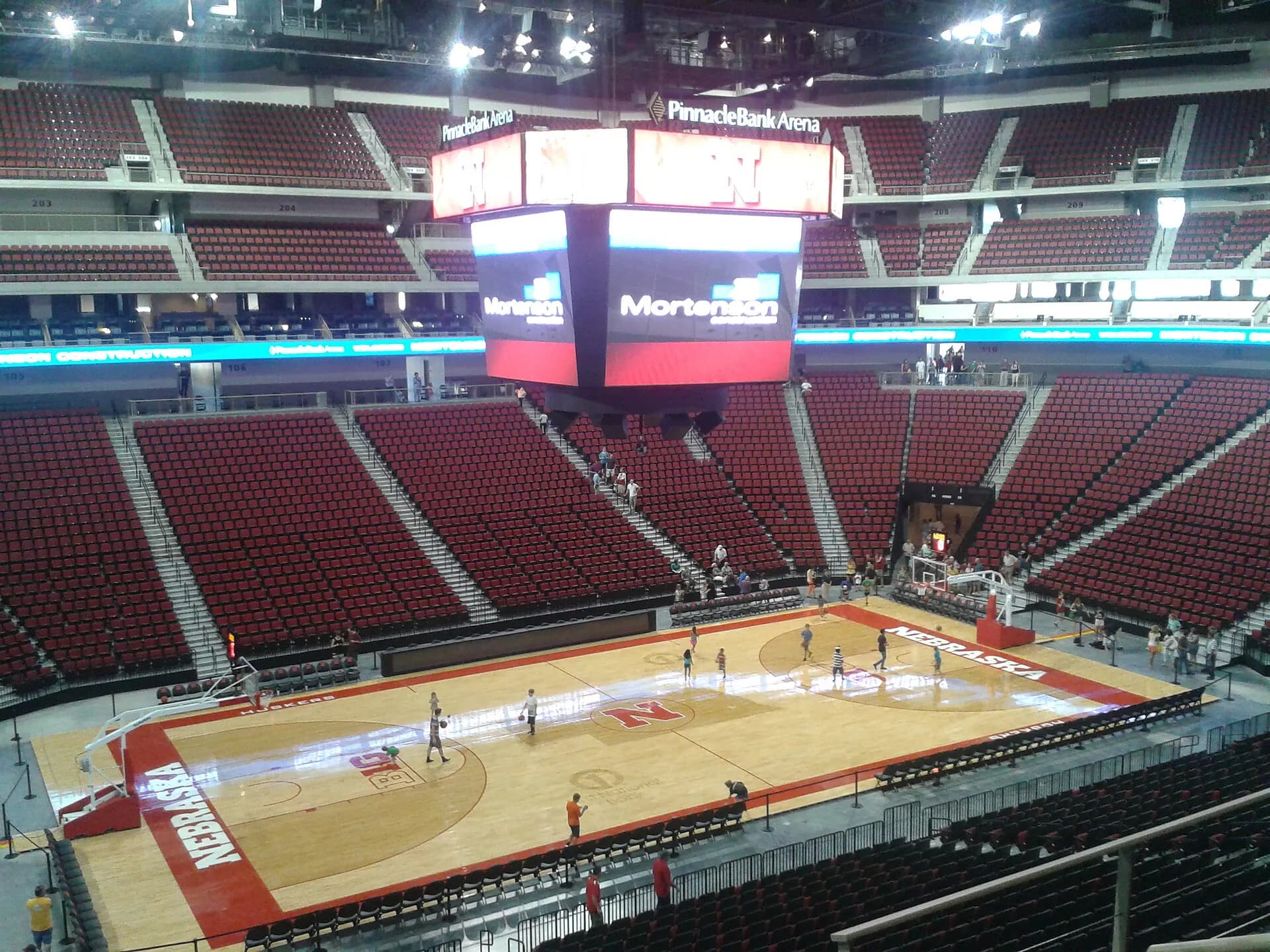 An empty basketball court and red seating inside Pinnacle Bank Arena.