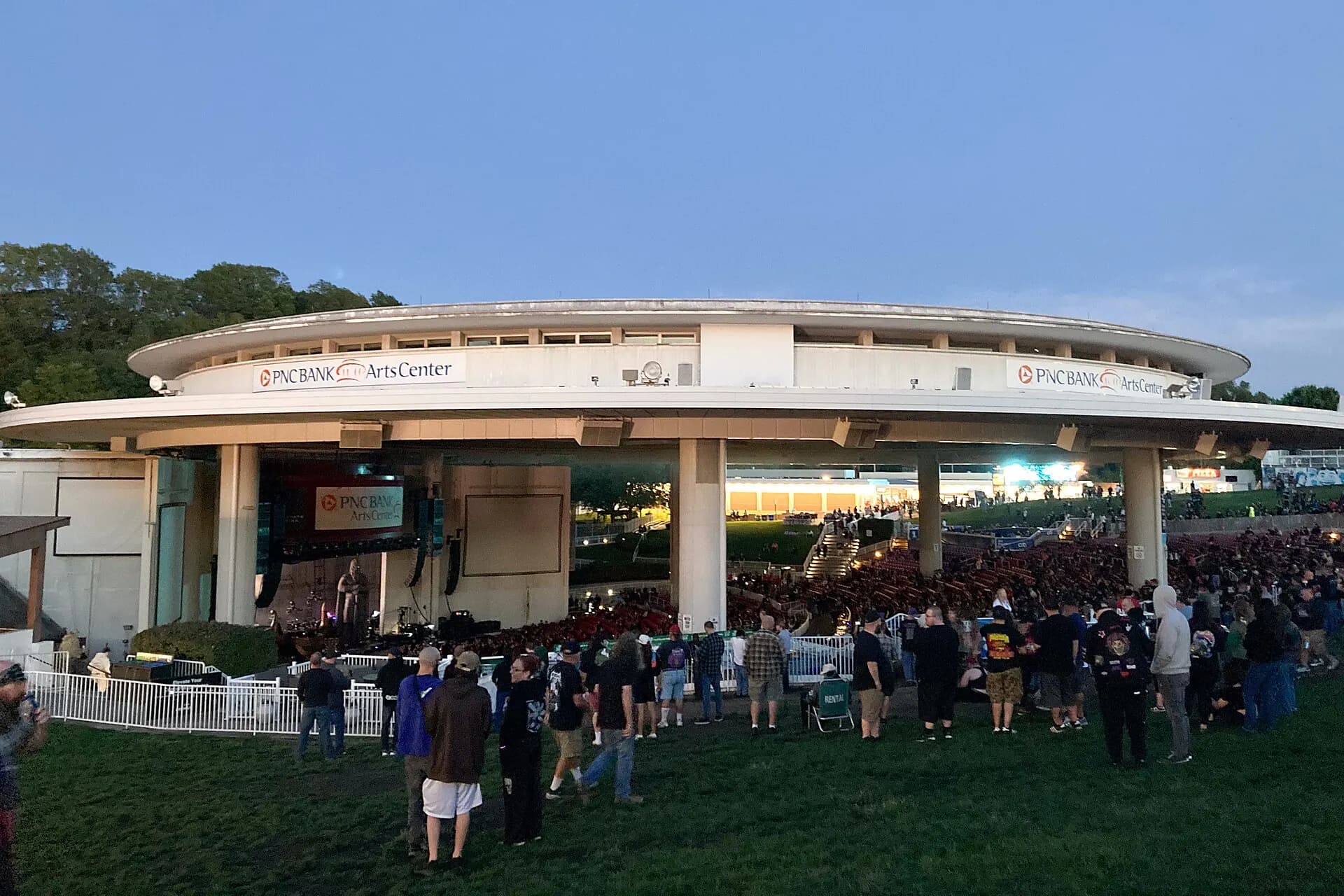 The pavilion exterior and arriving crowd at PNC Bank Arts Center in Holmdel.