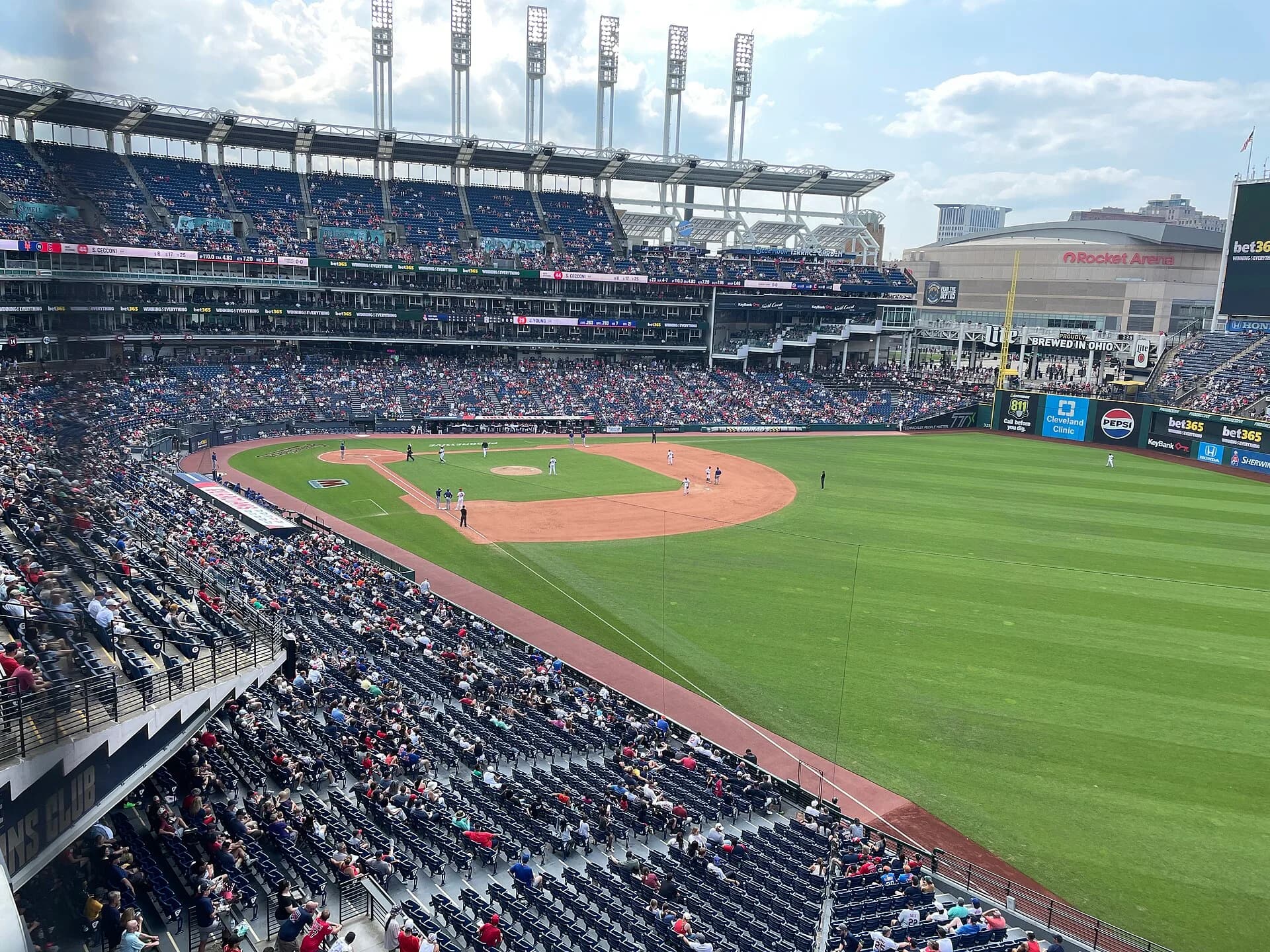 Progressive Field — elevated outfield-side view across the diamond on August 6, 2026, with the completed blue seating visible. Camera position is illustrative; match your own section and row.