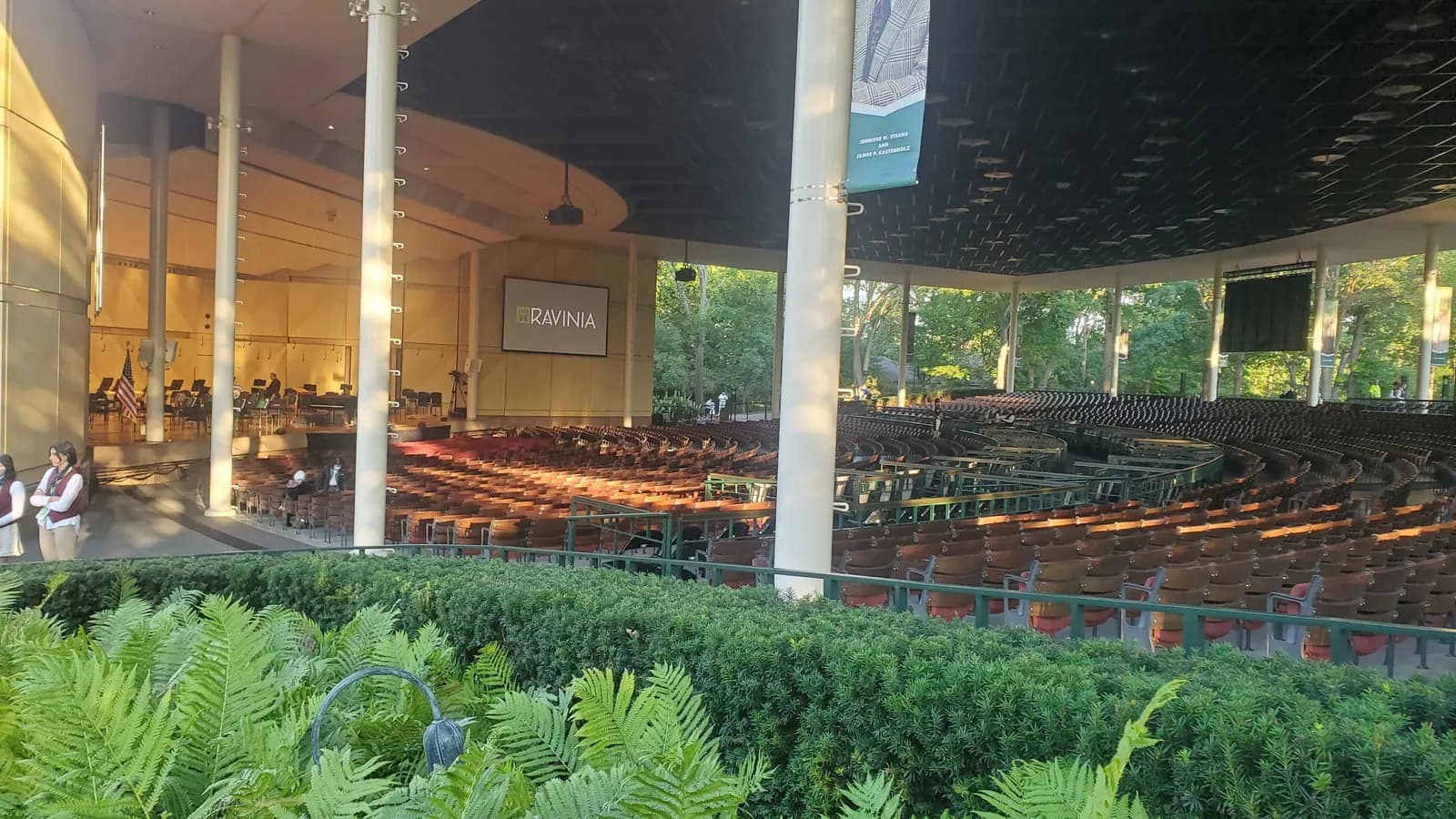 Wide view of the Ravinia Festival Pavilion seating and stage framed by greenery.