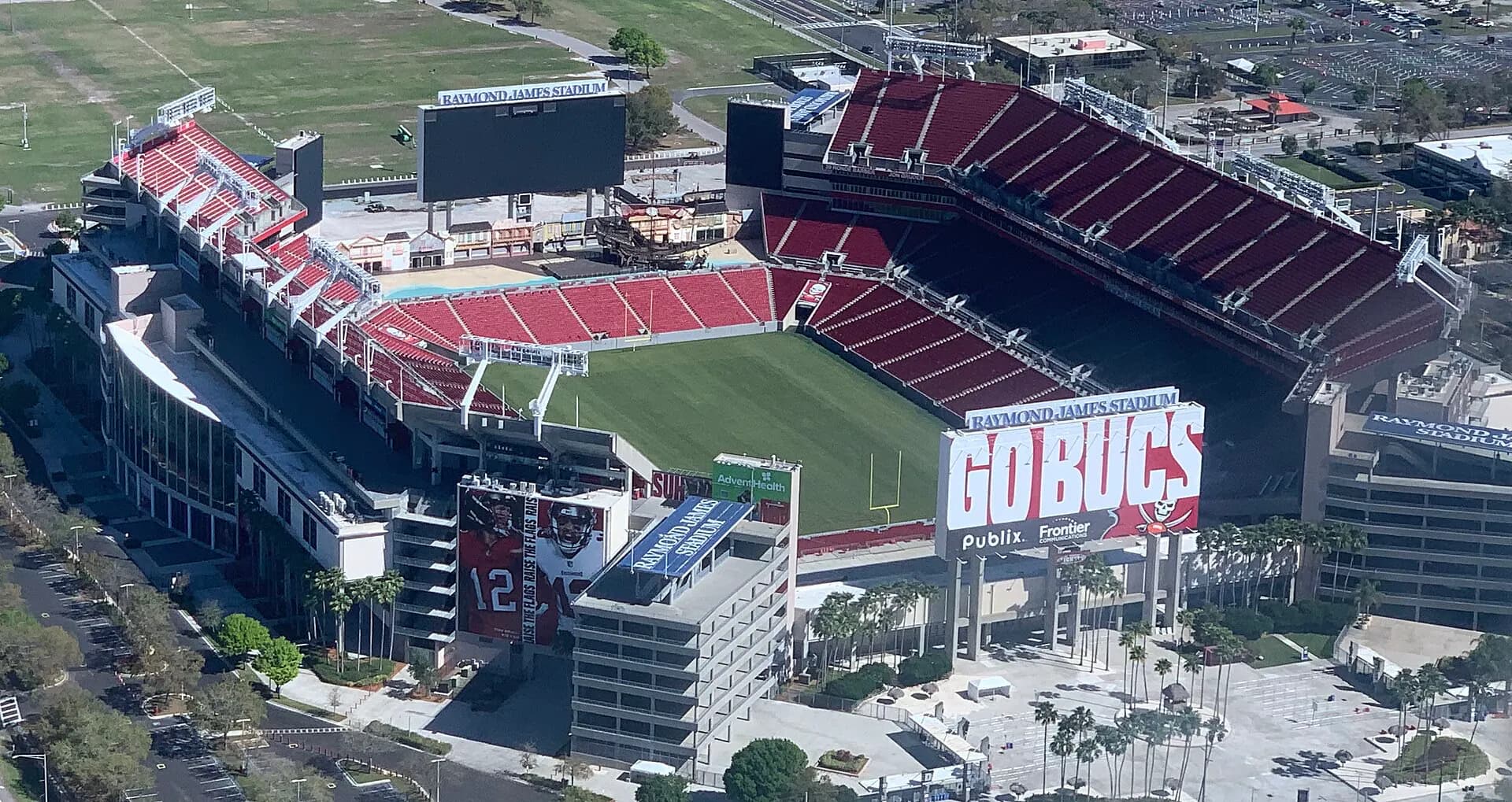 Aerial view showing the full seating bowl, field, video boards, and exterior approaches at Raymond James Stadium.