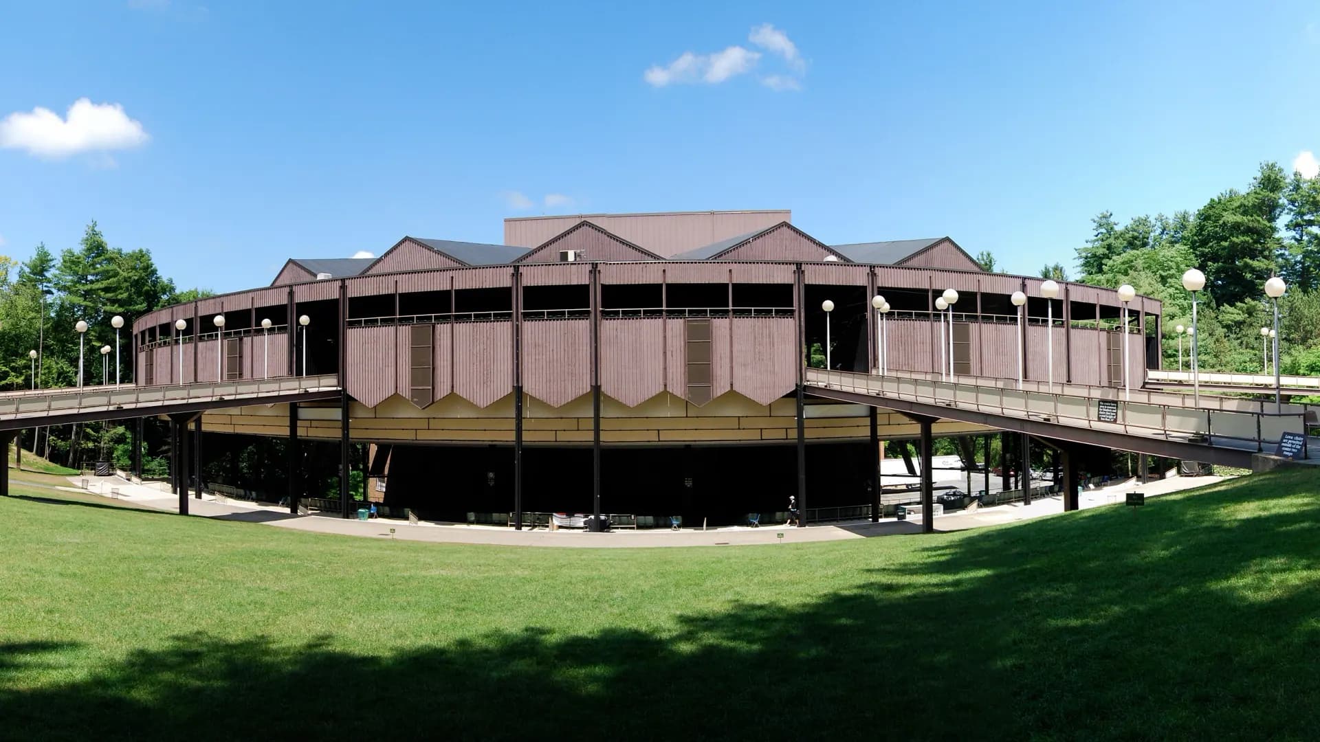 Wide exterior establishing view of the Saratoga Performing Arts Center pavilion and surrounding lawn.