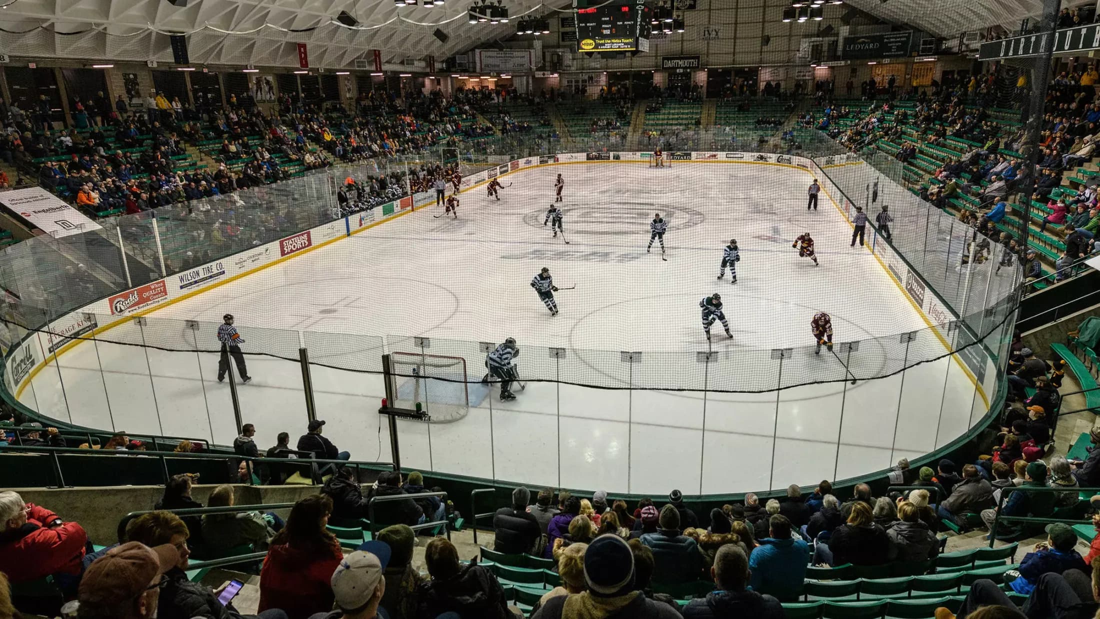 Thompson Arena’s occupied hockey bowl from an elevated goal-end position, documented by Dartmouth Athletics. Protective netting, glass and railings are visible. This older venue overview does not establish current advertising, an exact seat or a capture date.