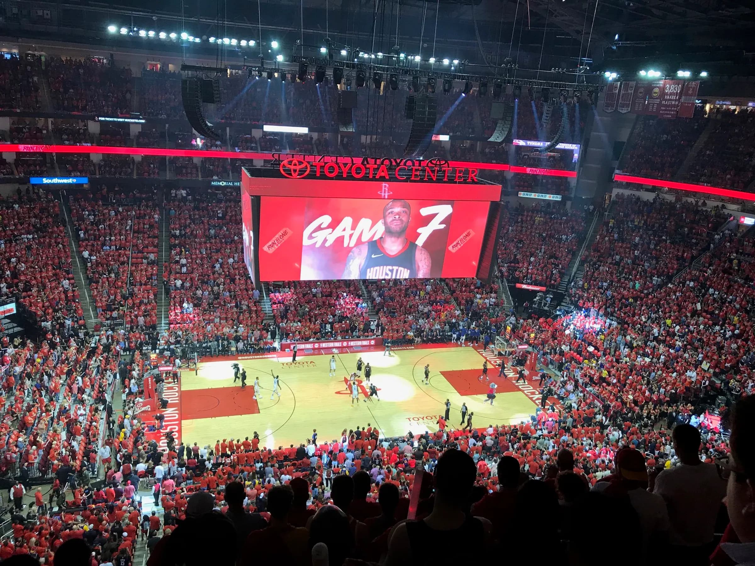 Packed upper-level view across the court and seating bowl inside Toyota Center.