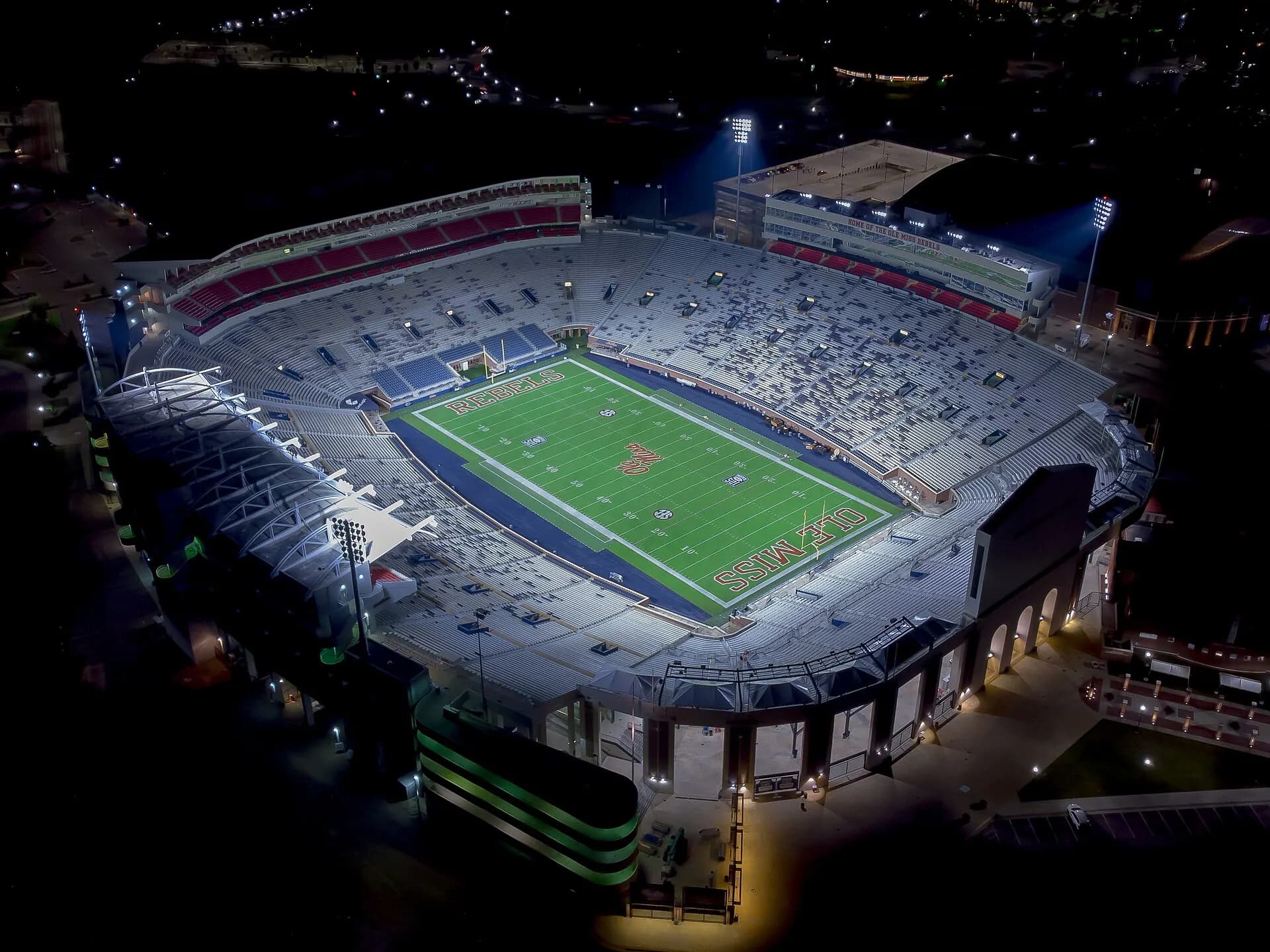 Night aerial showing the full field and seating bowl at Vaught-Hemingway Stadium.